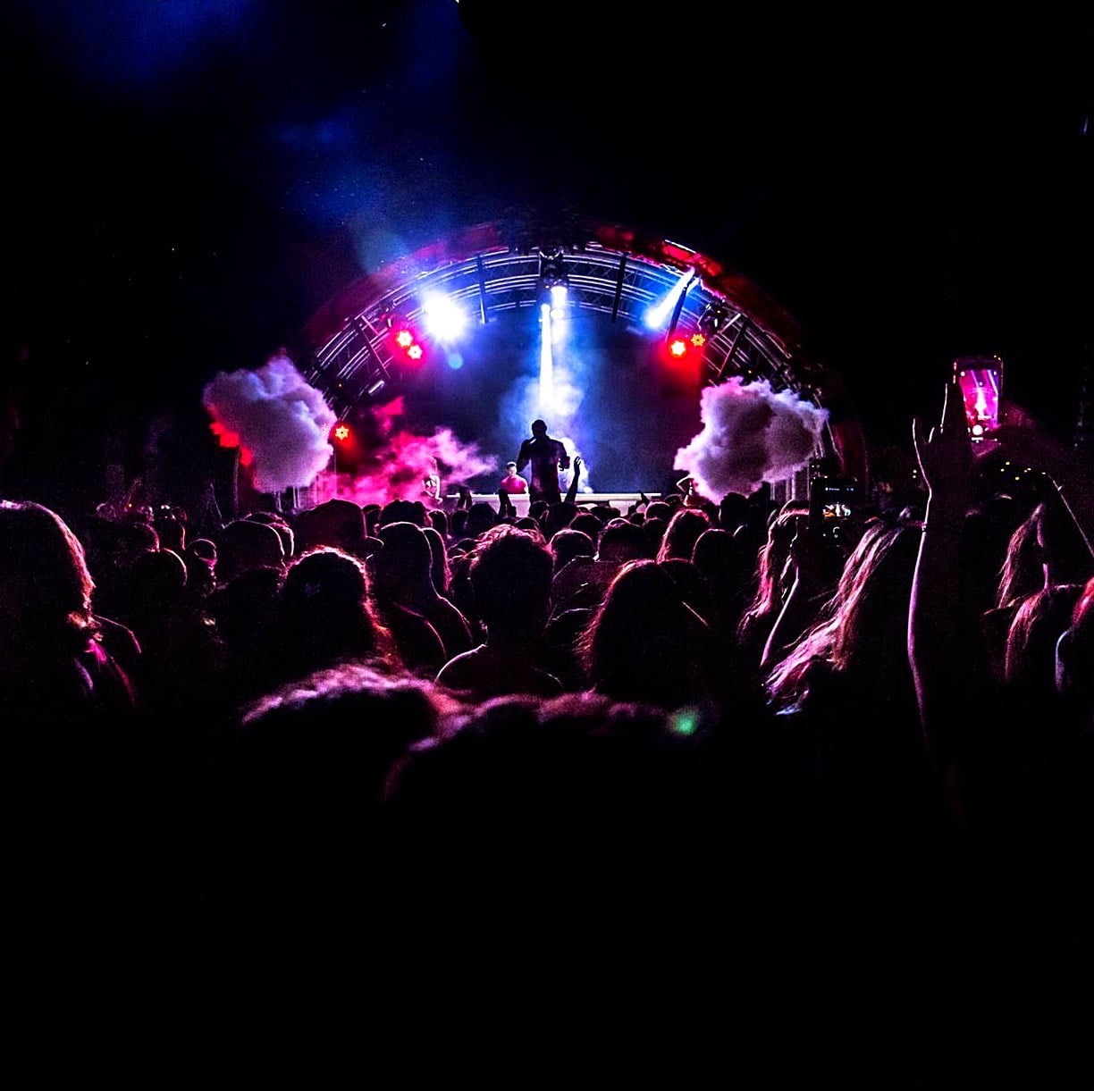 Photo d'une scene de festival de nuit avec du public et des jeux de Lumiere nightclubs